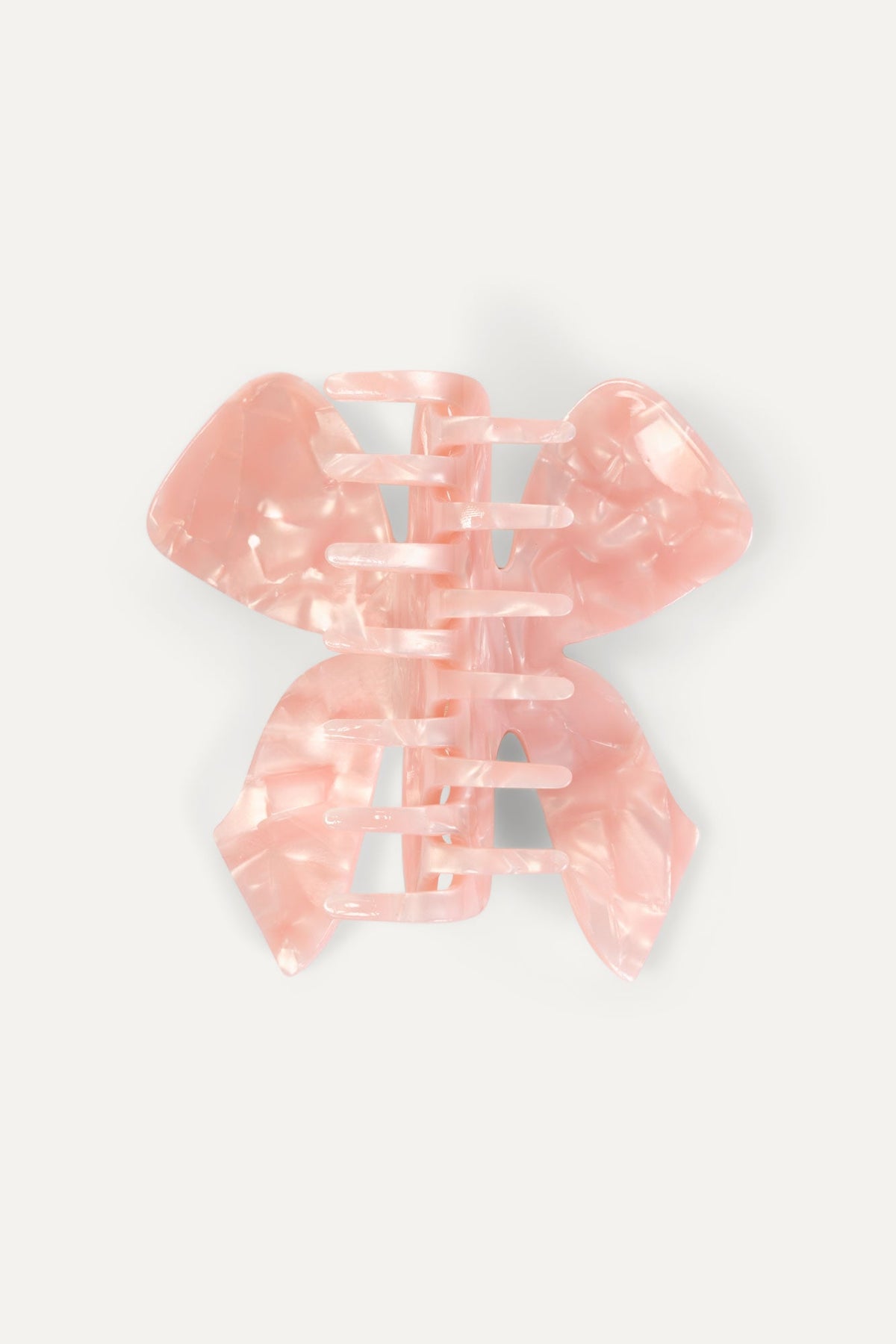 Pink translucent bow hair claw with layered wings, angled view
