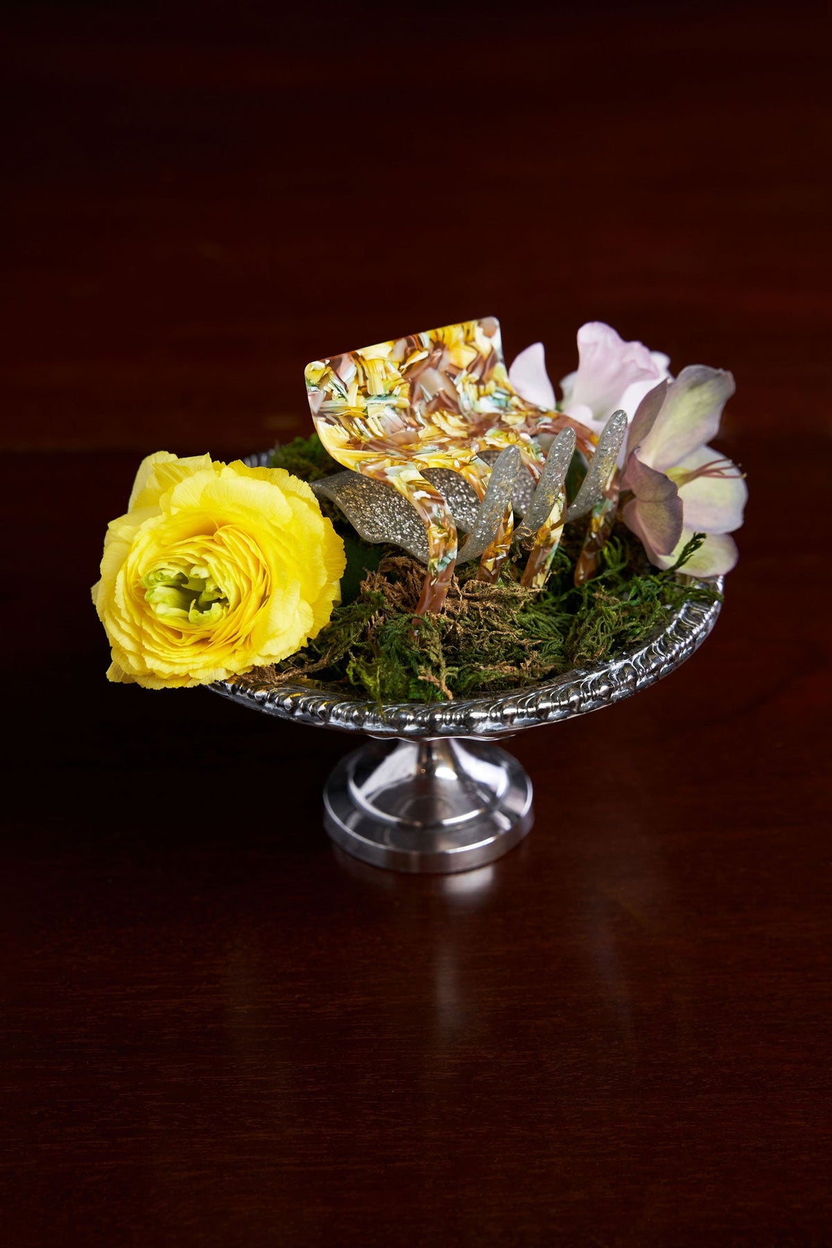 Decorative hair claw with silver prongs, iridescent yellow-orange resin and small flowers