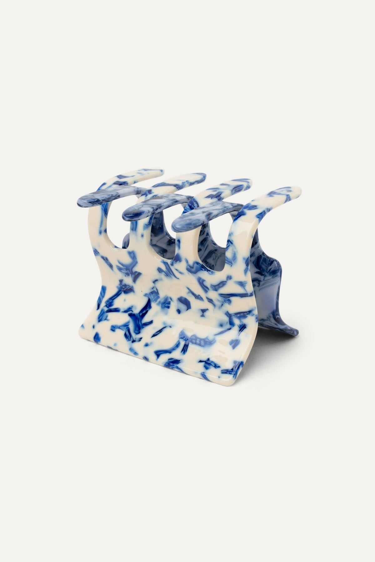 Delft blue patterned hair claw with white base, curved prongs for holding hair