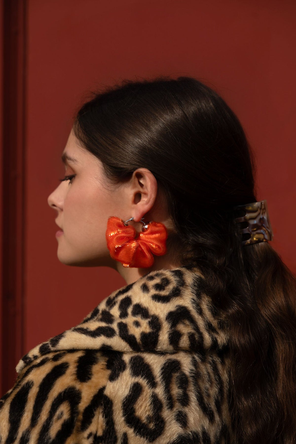 Mini gold-toned hair claw clip on dark hair