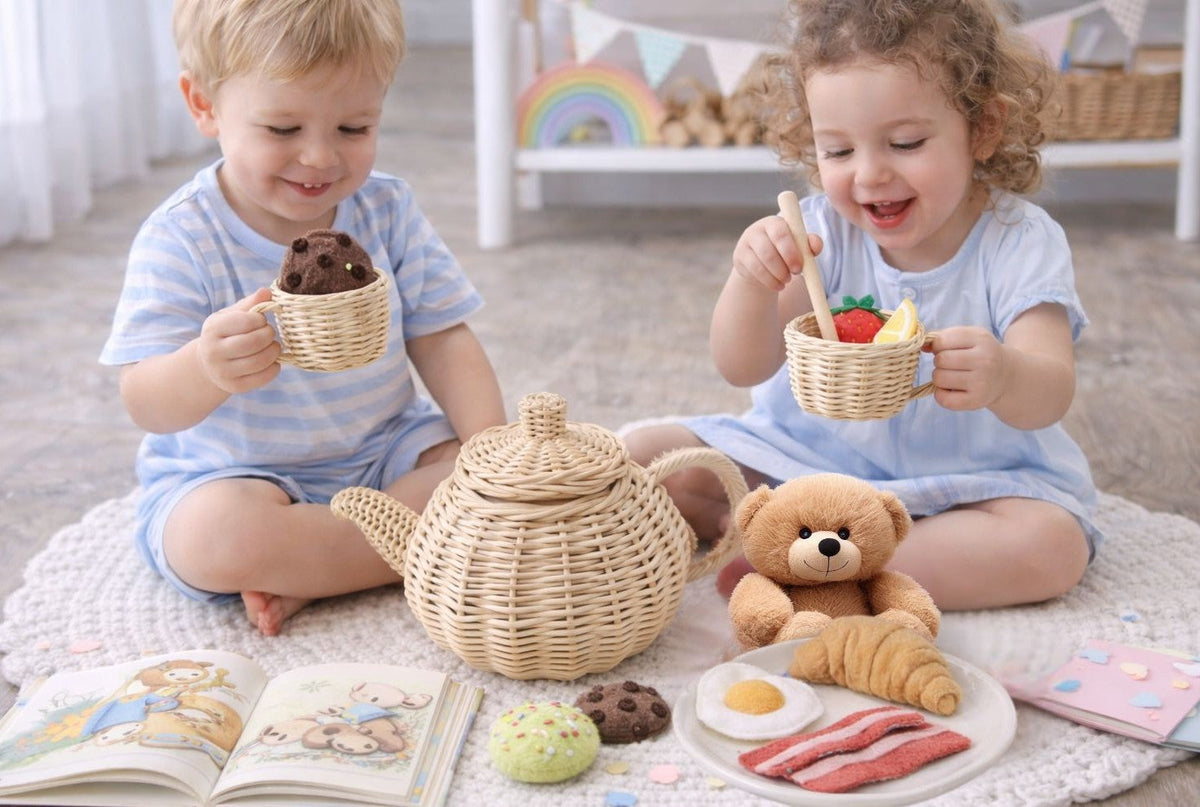 Wicker toy teapot and two cups held by children during pretend tea
