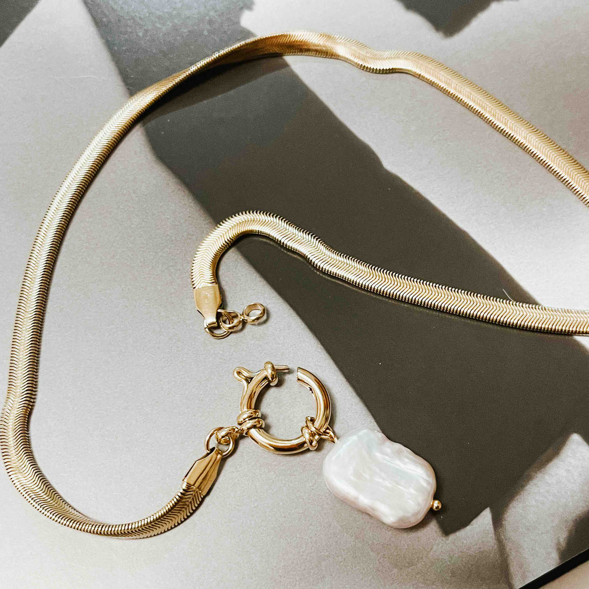 Gold-tone necklace with toggle clasp and mother-of-pearl drop pendant
