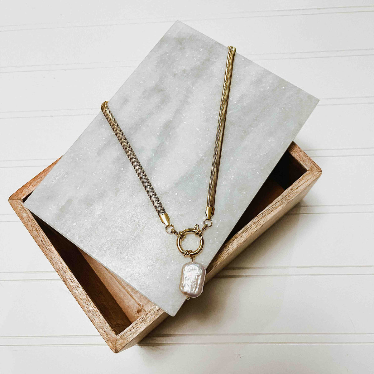 Gold-tone mother-of-pearl pendant necklace with long chain and teardrop charm