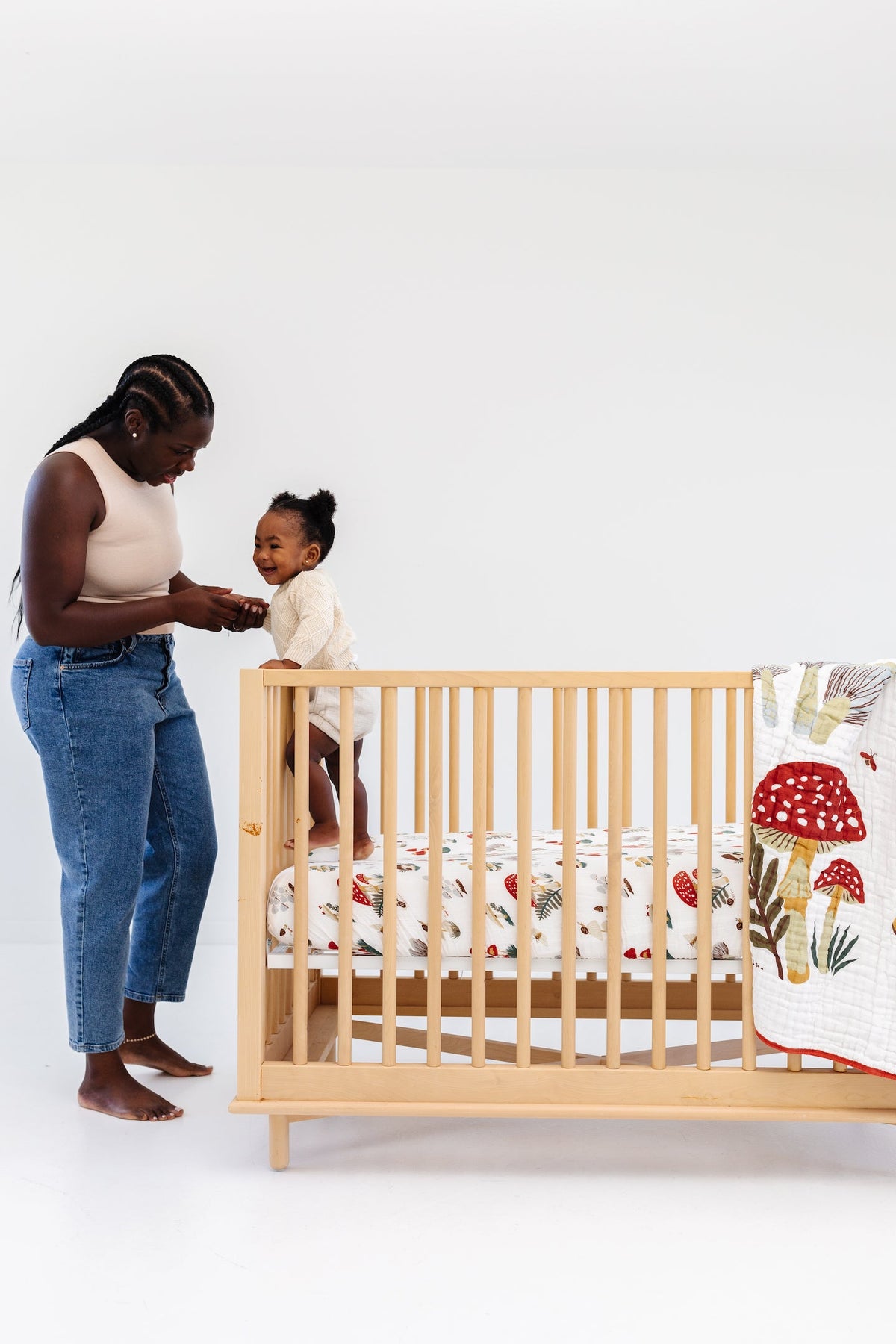 Crib fitted sheet with white fabric and red-and-brown mushroom pattern