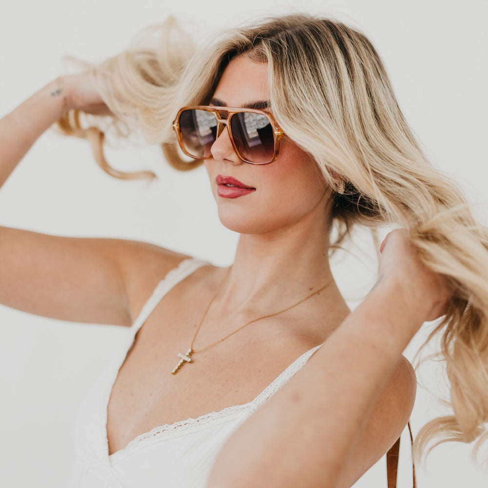 Oversized aviator sunglasses on model with warm tortoiseshell frame and tinted lenses