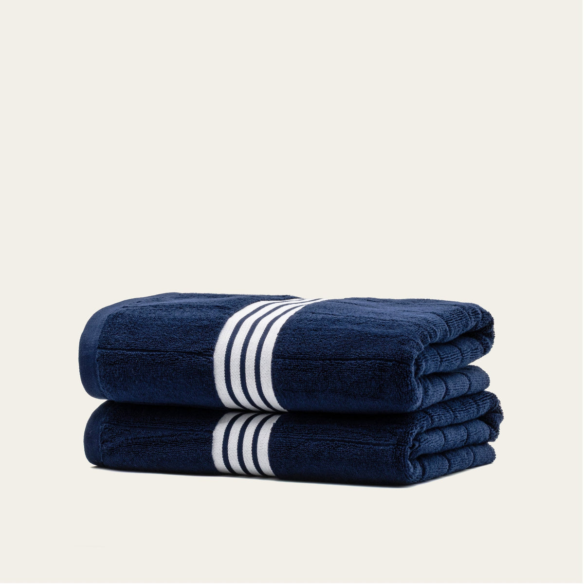 Navy cotton towels with white striped bands, folded stack of two towels.
