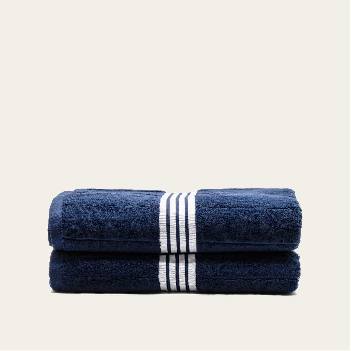 Navy cotton towel set with white striped bands, two towels folded side by side.