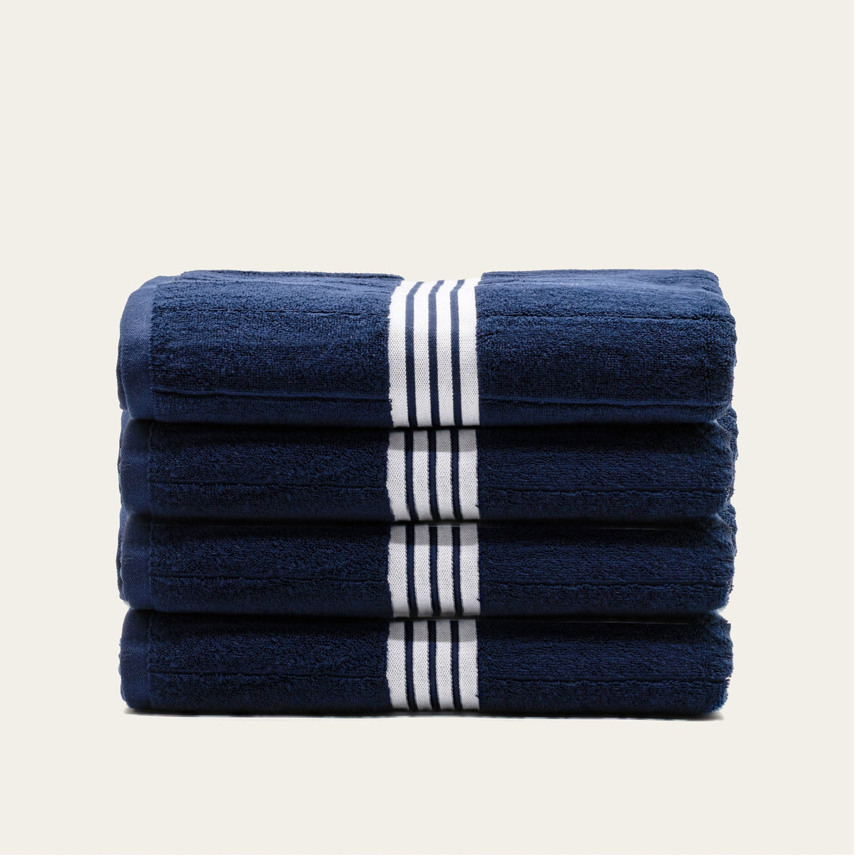 Stack of navy bath towels with white triple-stripe bands