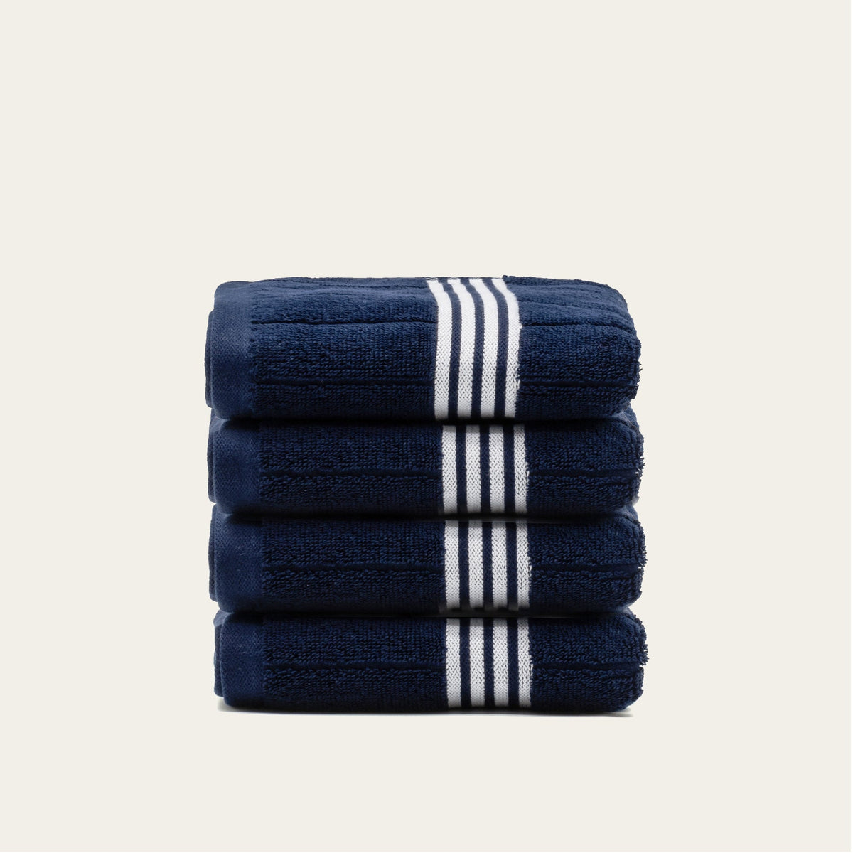 Folded navy towels with white triple-stripe bands