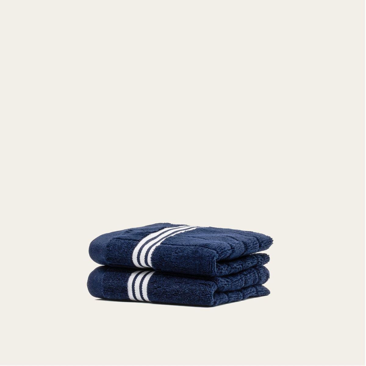 Nautilus navy cotton towels with white striped bands, folded stack of two