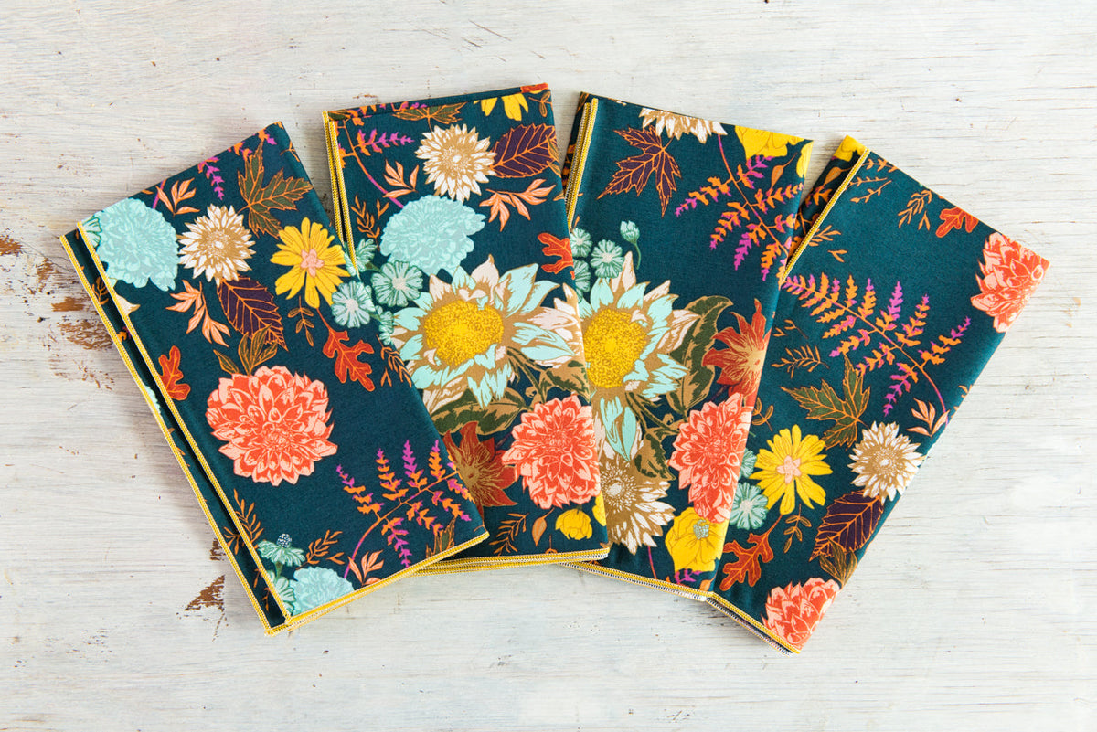 Set of four blue floral cloth napkins with multicolor flower and leaf pattern