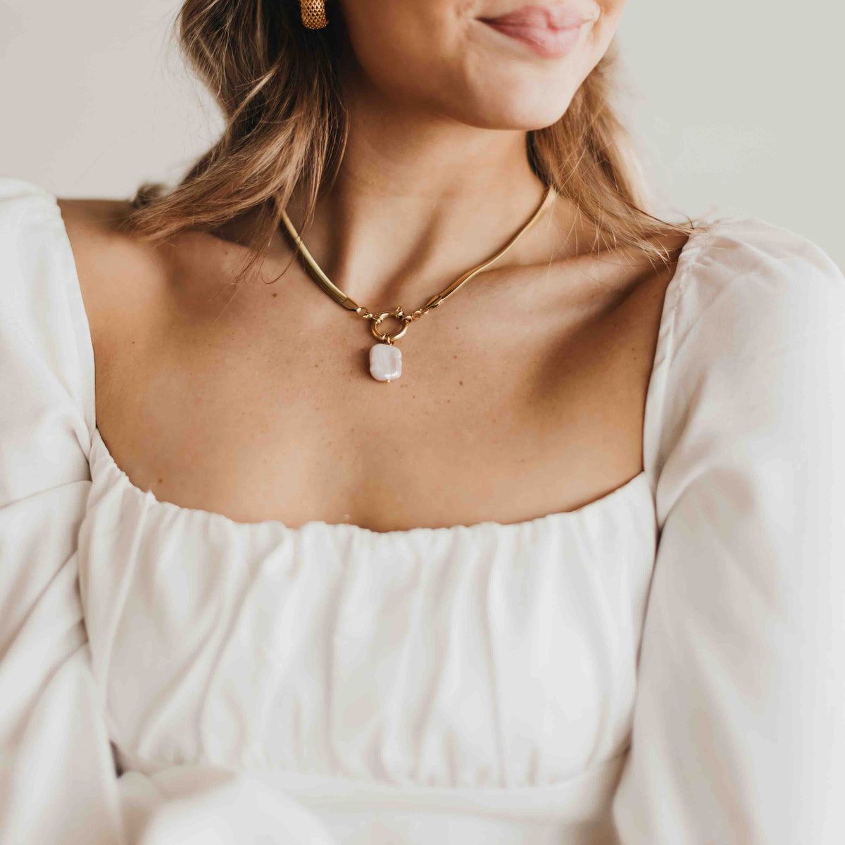 Gold-tone pendant necklace with mother-of-pearl teardrop charm