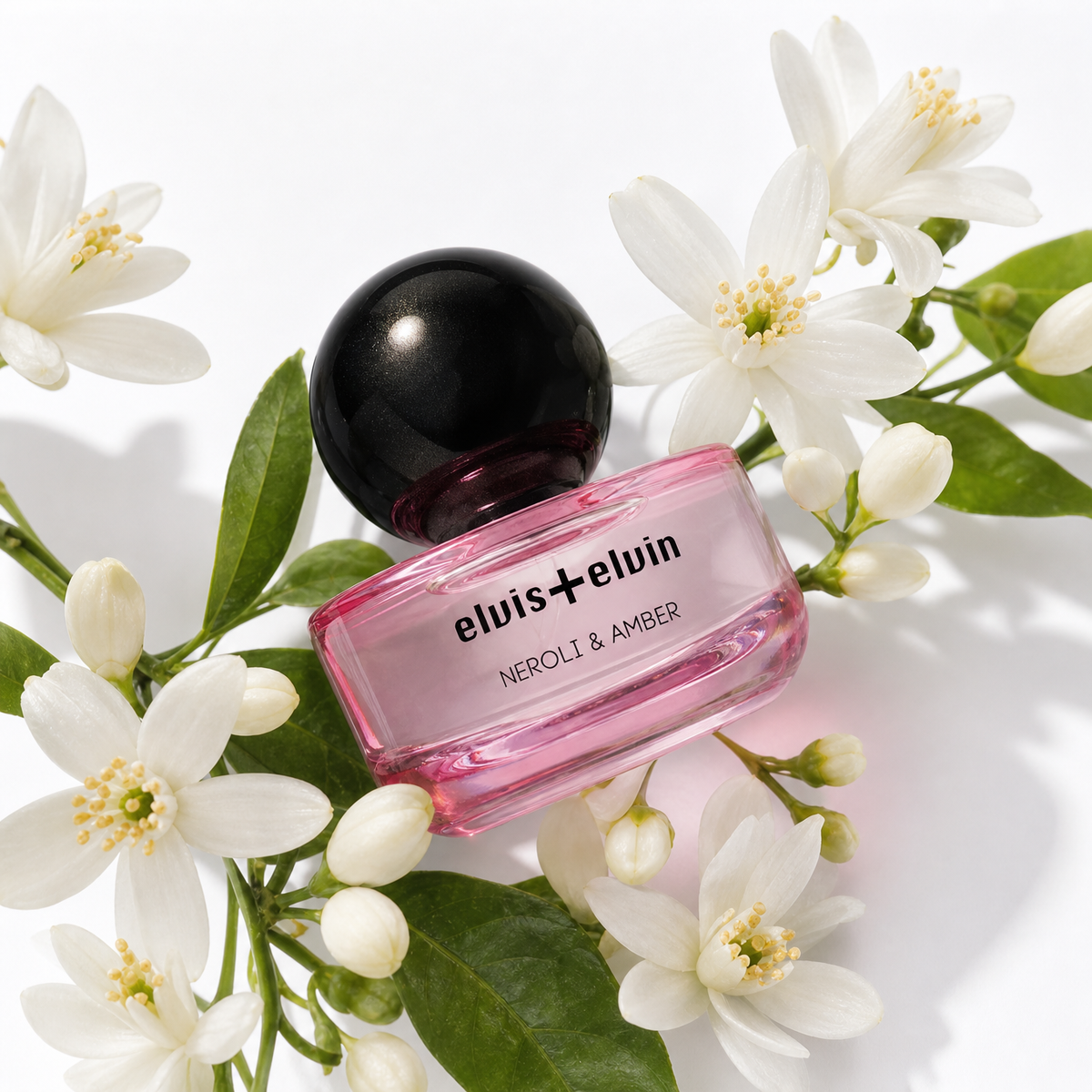 Pink glass parfum bottle with black dome cap and rectangular base