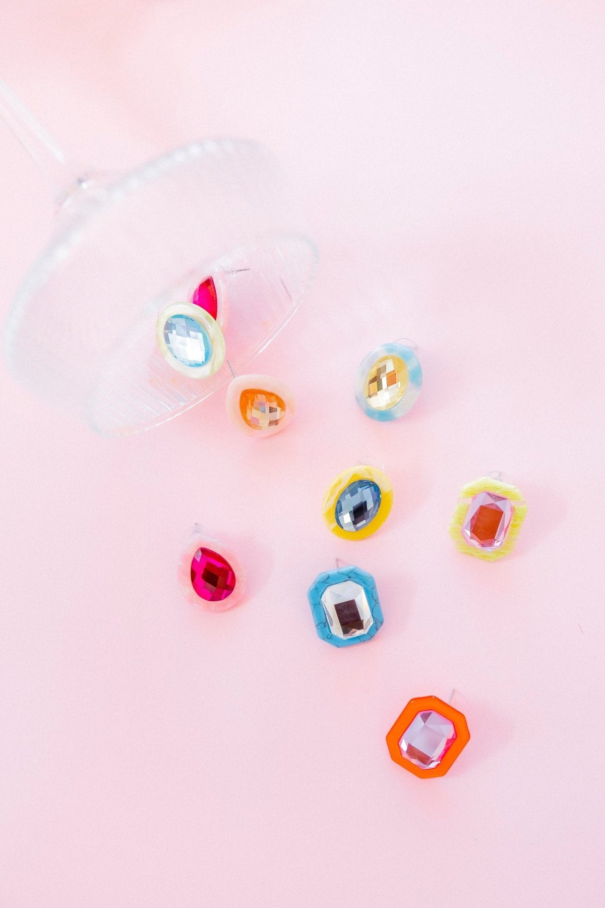 Assorted earrings with faceted stones, including blue oval piece with light yellow setting