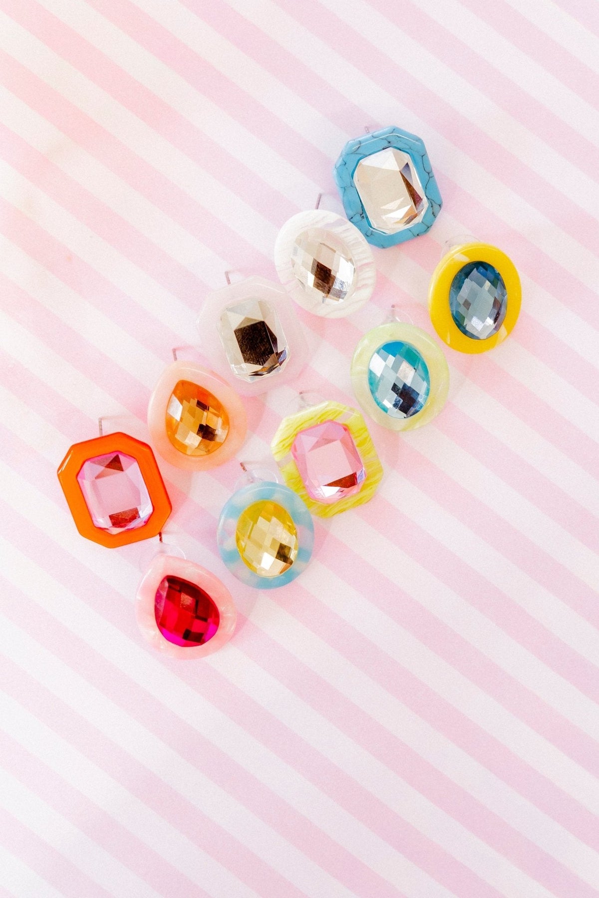 Assorted statement earrings with colorful faceted stones, including blue oval pair