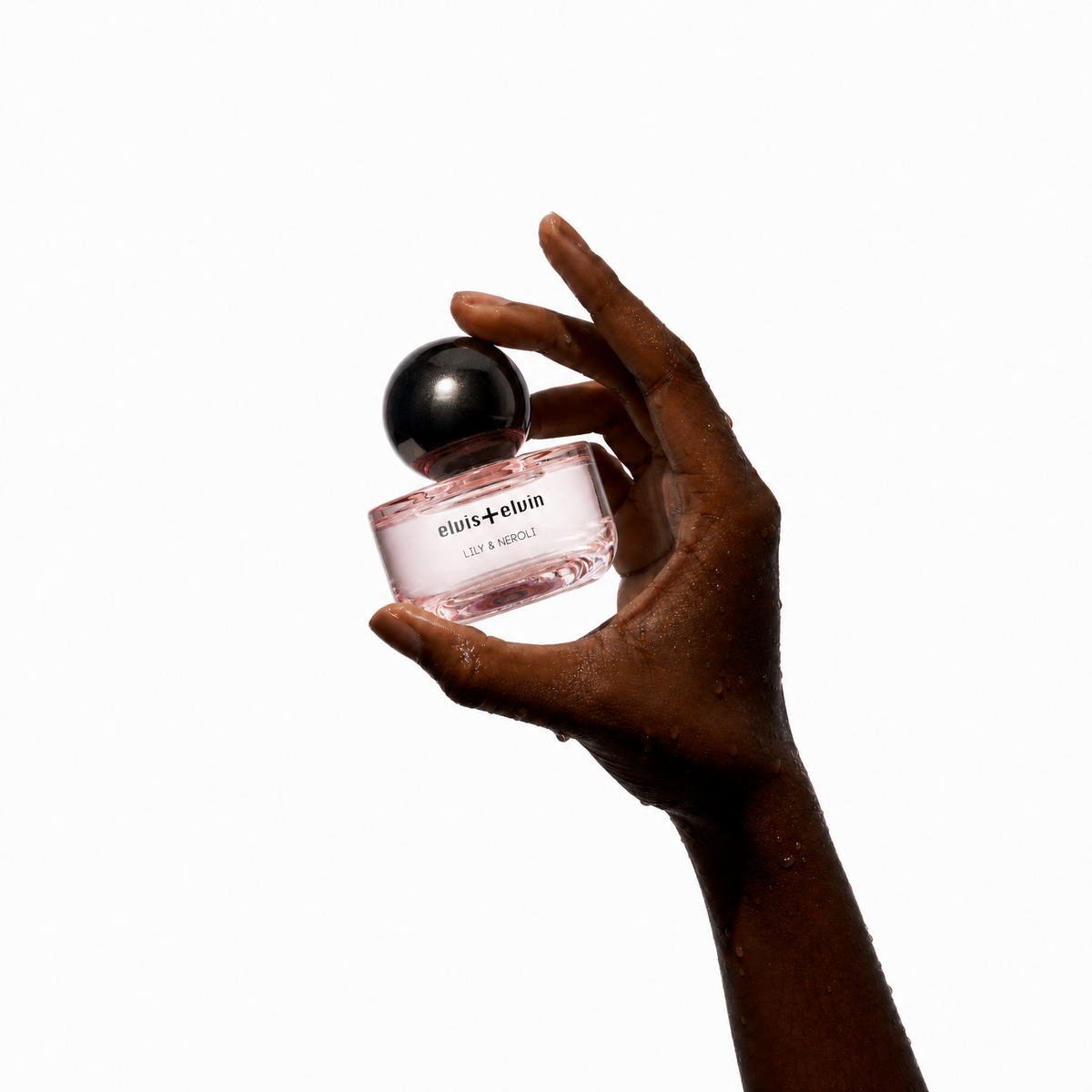 Lily & Neroli perfume bottle held in a cupped hand with black sphere cap