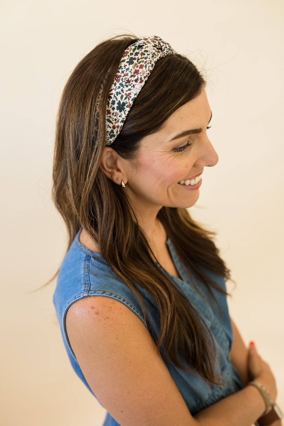 Floral knotted headband worn over long hair, cream base with multicolor botanical print