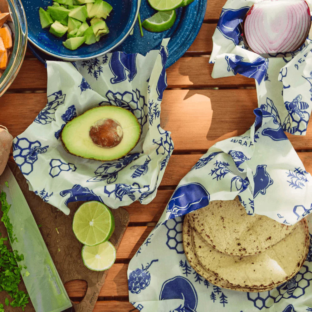 Bee’s Wrap wax food wraps with blue floral animal print covering avocado and lime