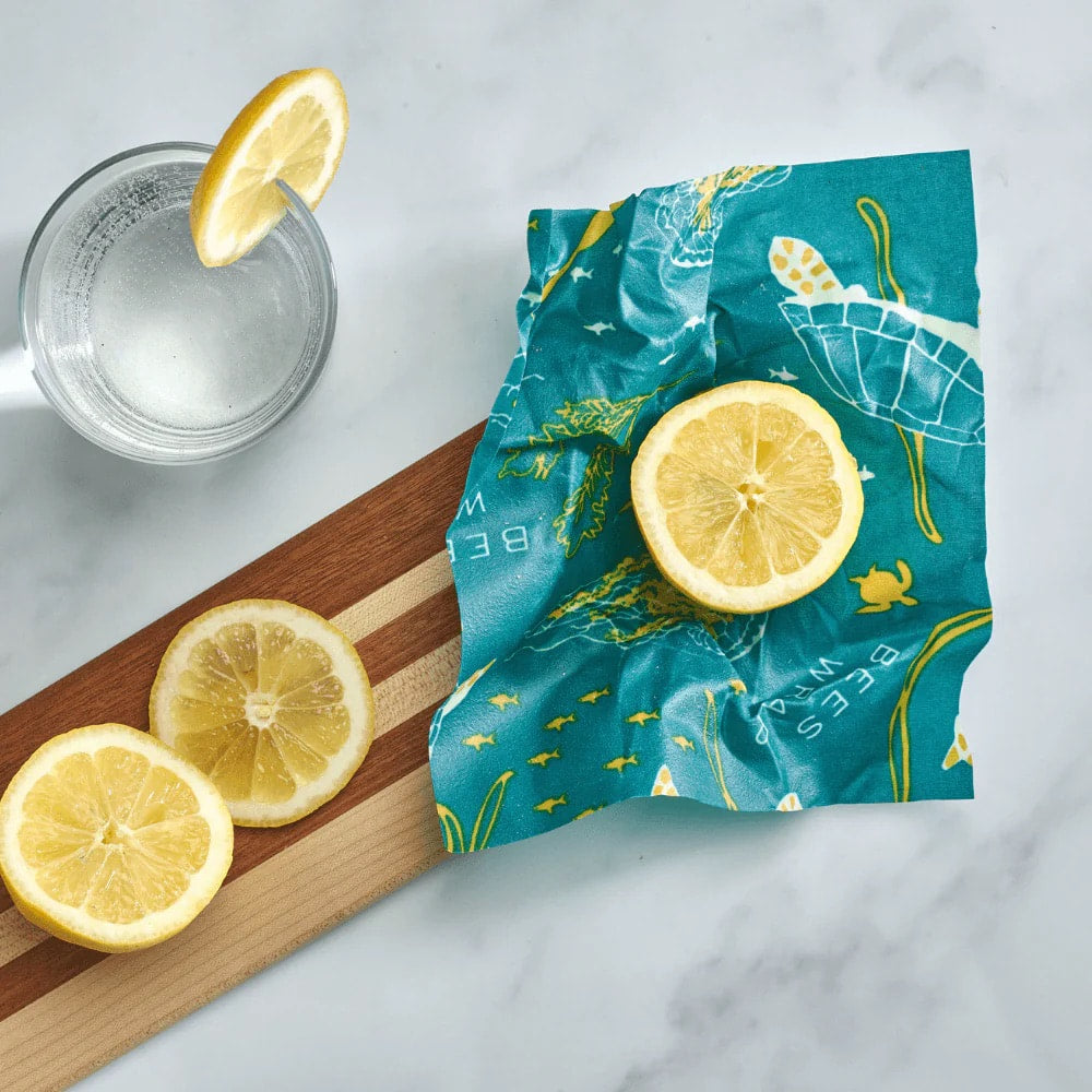 Blue Bee's Wrap food wrap with lemon slices and a candle-like glass nearby