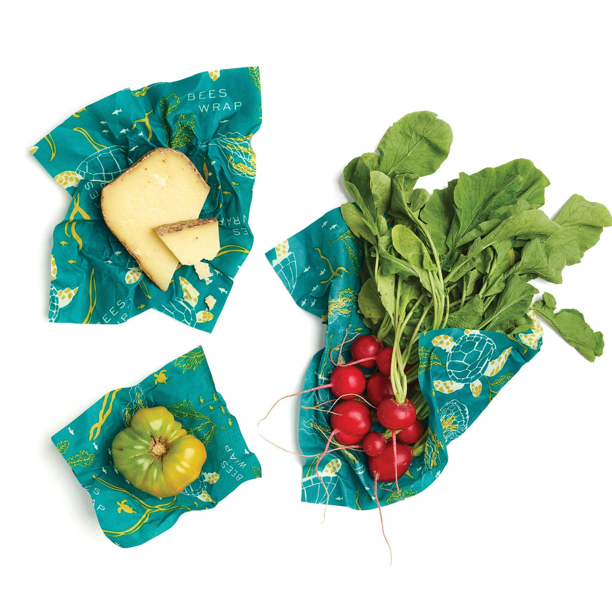 Bee's Wrap food wraps with cheese, greens, tomatoes, and sliced vegetables