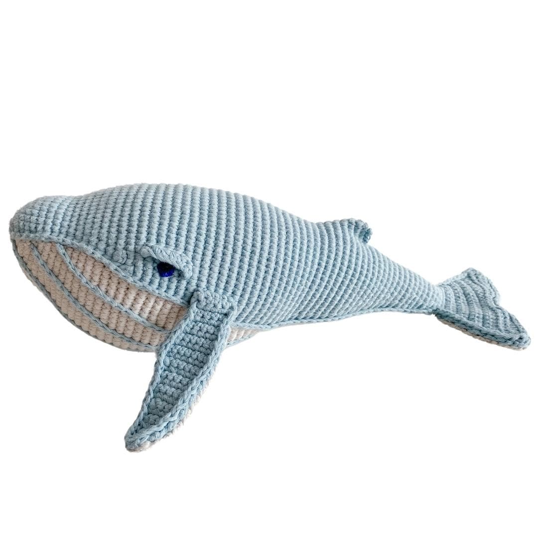 Misty blue crocheted whale plush with a cream striped belly and stitched fins.