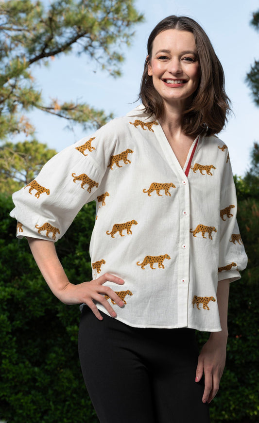 Ivory embroidered cheetah print blouse, V-neck with red trim and button-front
