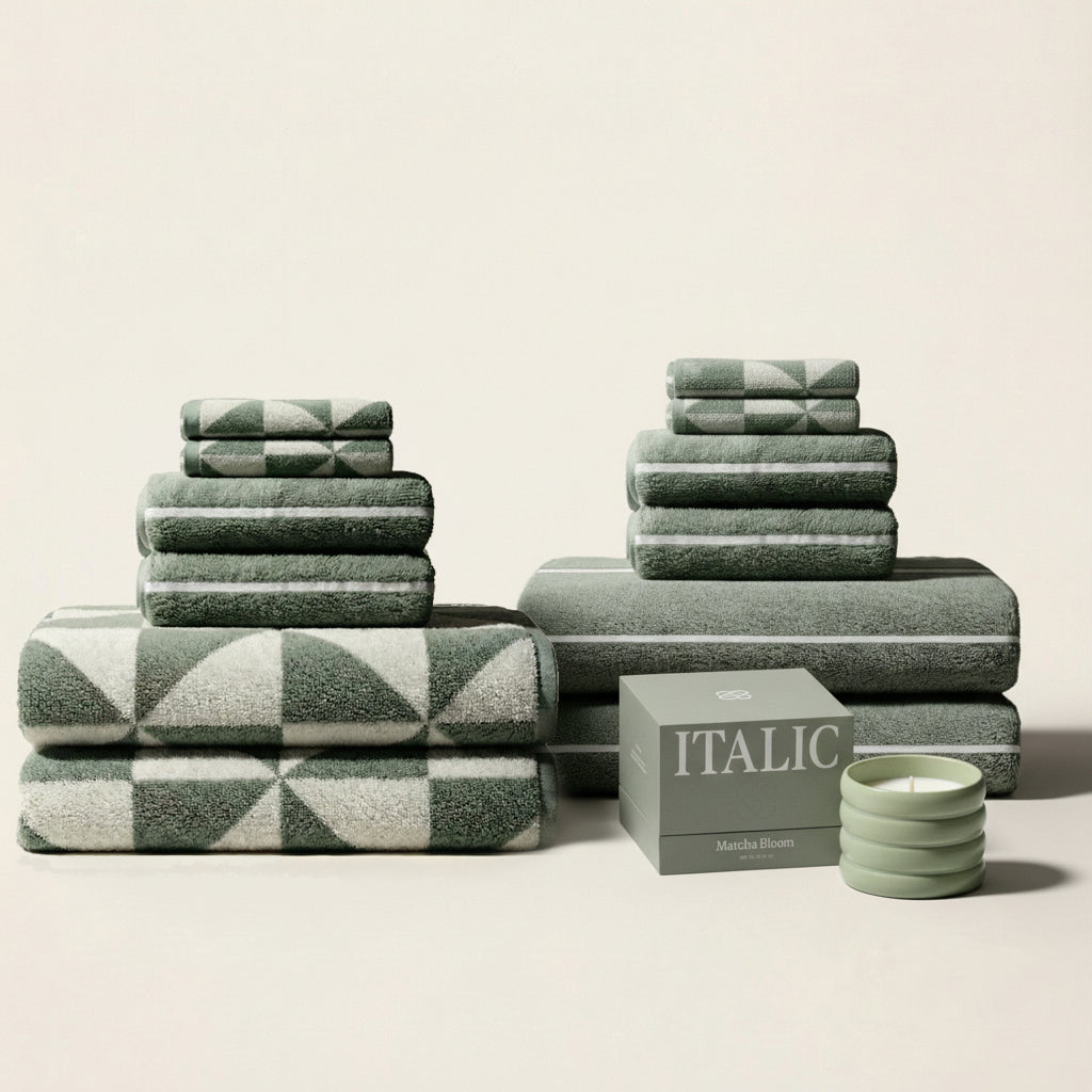 Sage green and ecru striped cotton towels with folded stacks and accessories