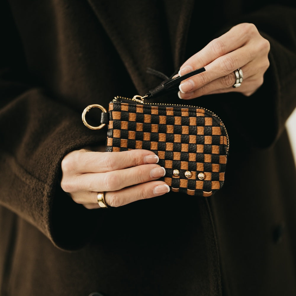 Brown and black checkered card wallet with gold zipper, key ring, and tassel.
