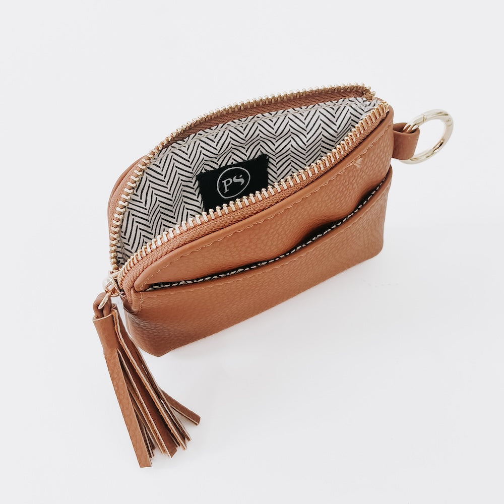 Tan pebble card wallet with zip closure, key ring, tassel, and herringbone lining