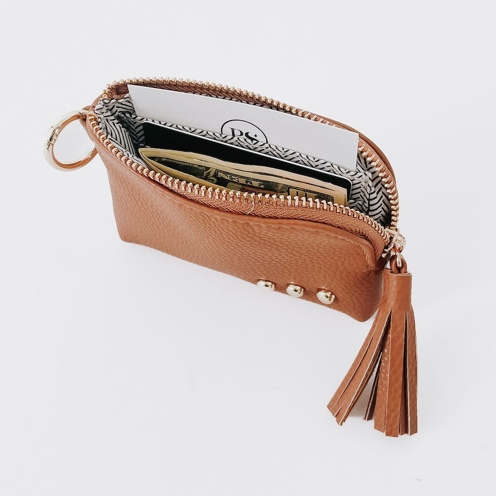 Tan pebble card wallet with open card pocket, zip closure, tassel, and key ring