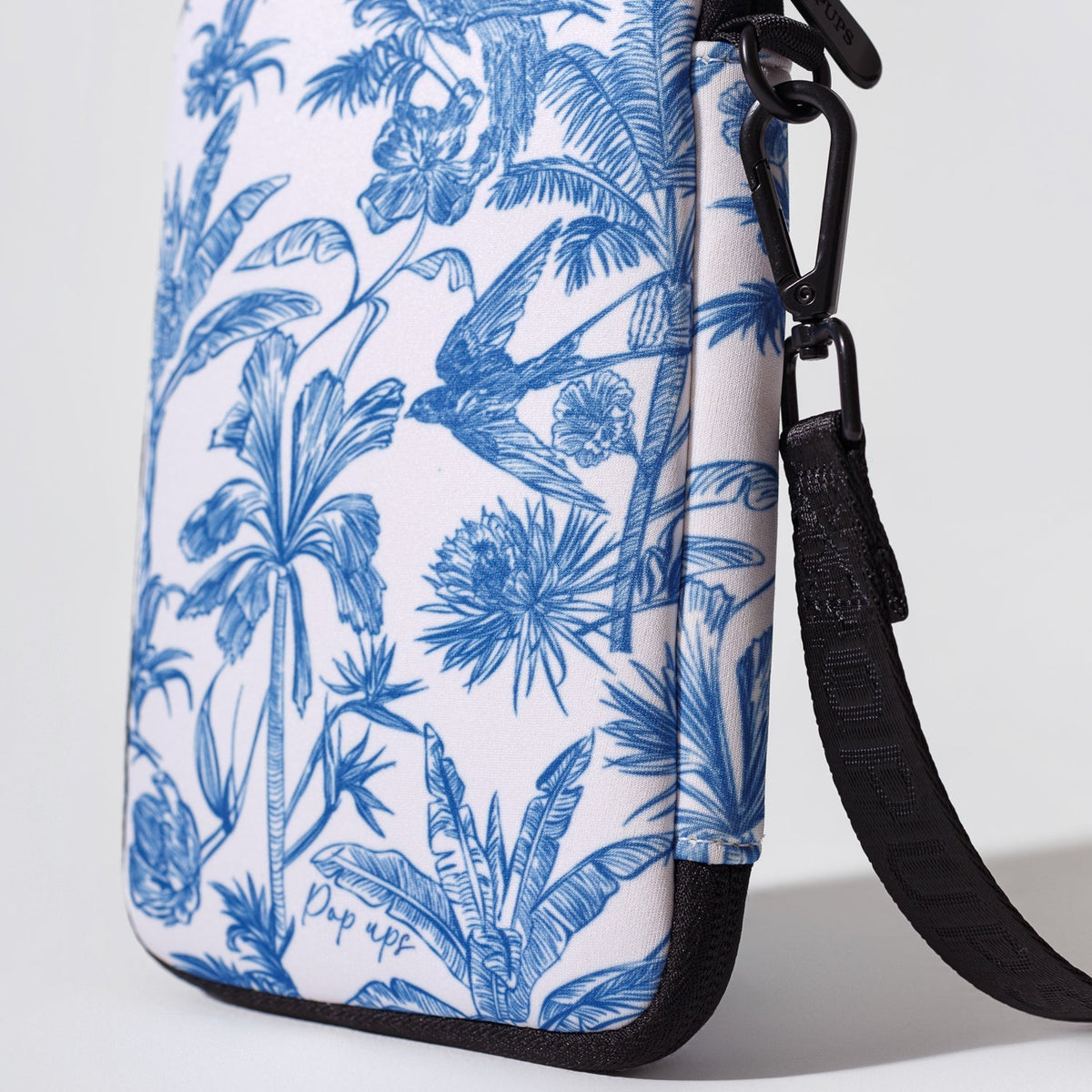 Blue toile passport wallet with black crossbody strap and carabiner clip detail