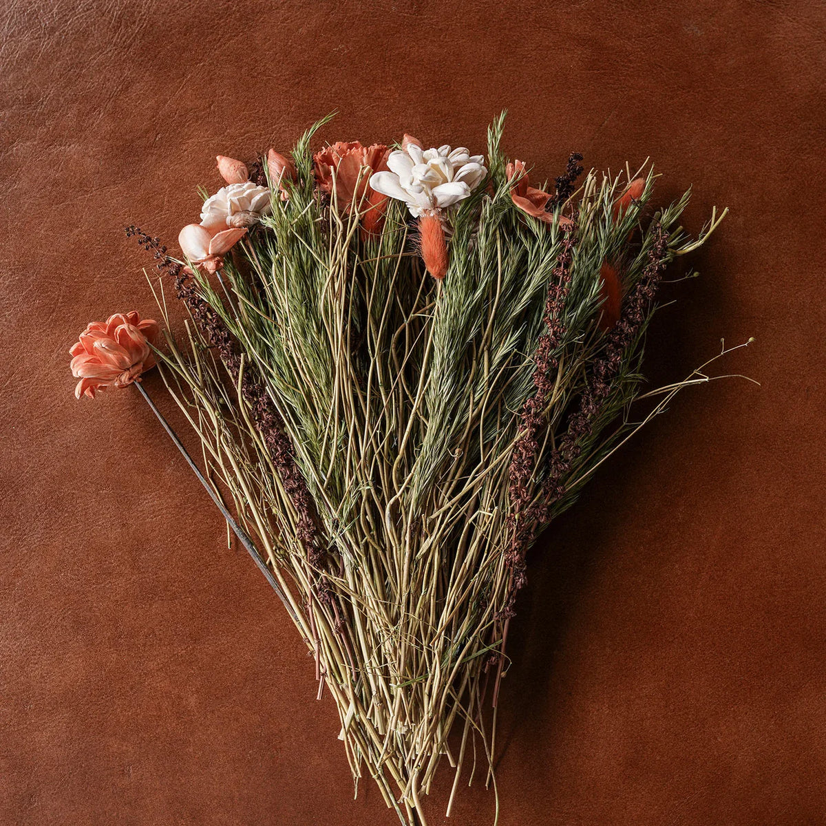 Dried floral and grass bouquet with peach, blush, and white rose-like blooms