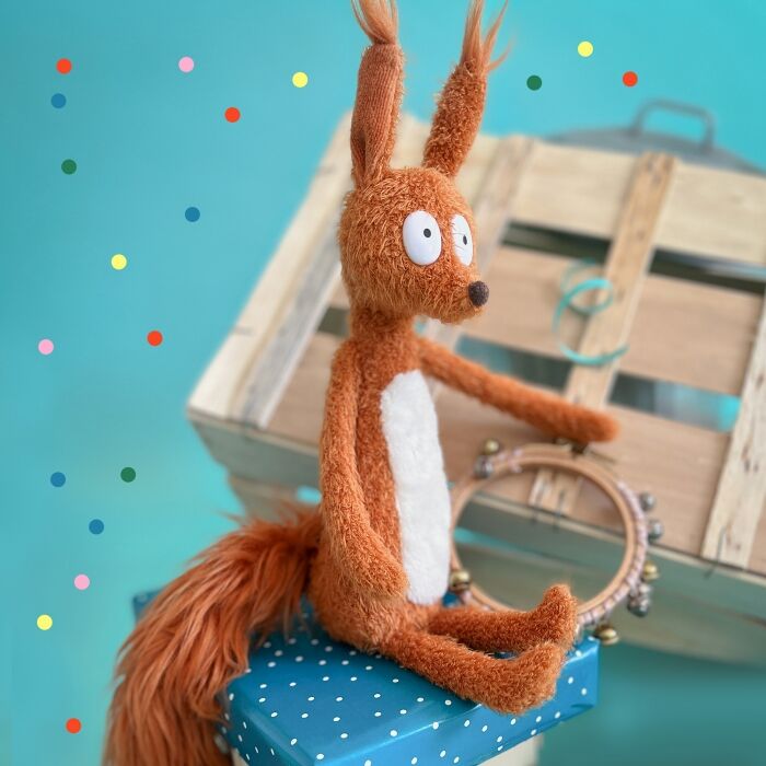 Brown plush squirrel plush with white belly patch and outstretched arms, seated