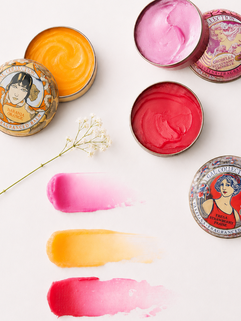 Perfumeria Gal scented lip balms in open tins with pink, orange, and red swatches
