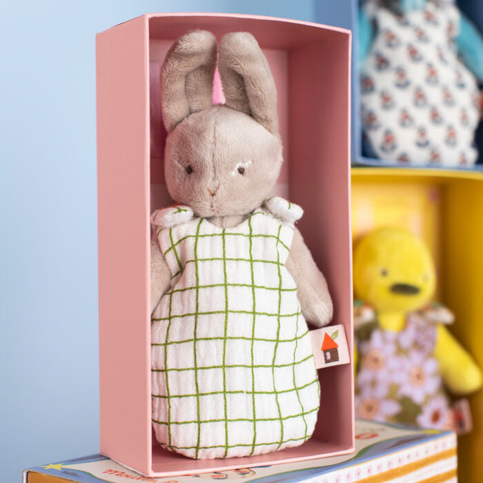 Plush rabbit doll in a white grid-pattern dress, displayed in an open pink box