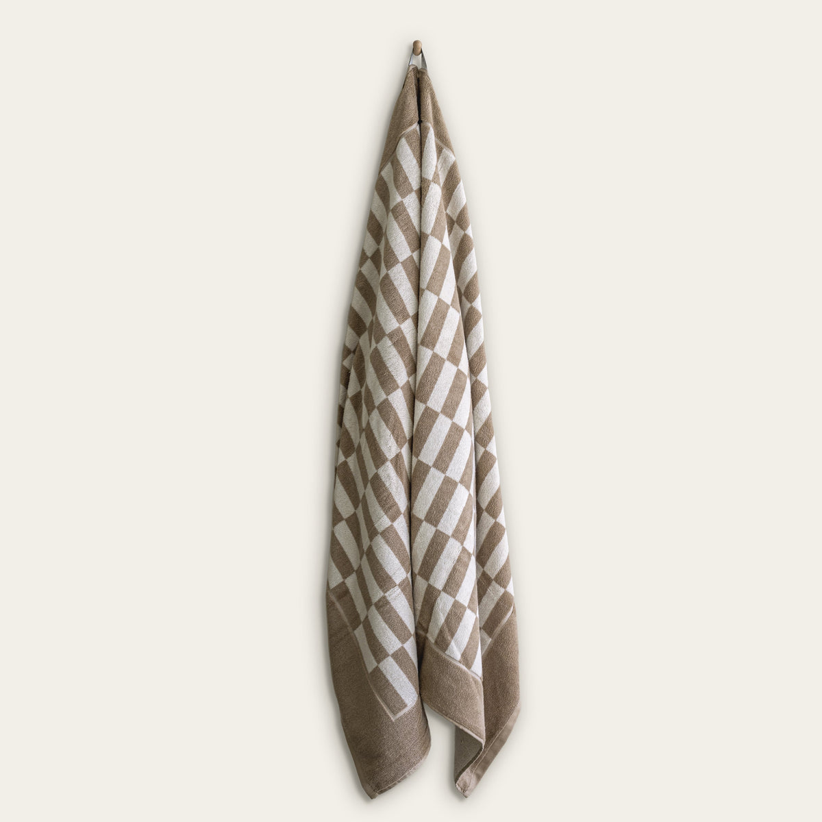 Checkered cotton towel in tan and ecru hanging display