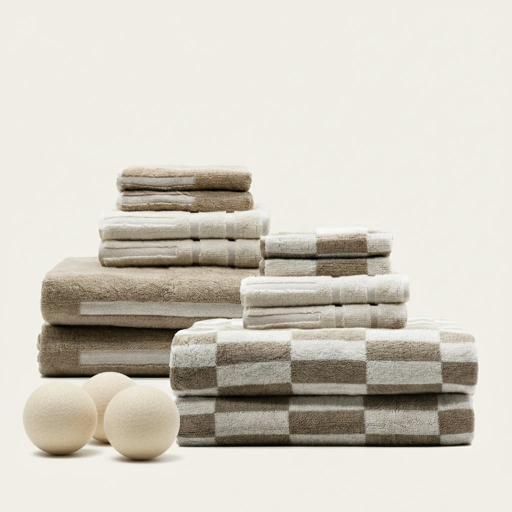 Stack of beige, ecru, and check plaid cotton towels with folded layers