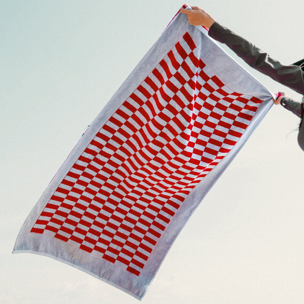 Red and white checkered cotton towel hanging and unfolded