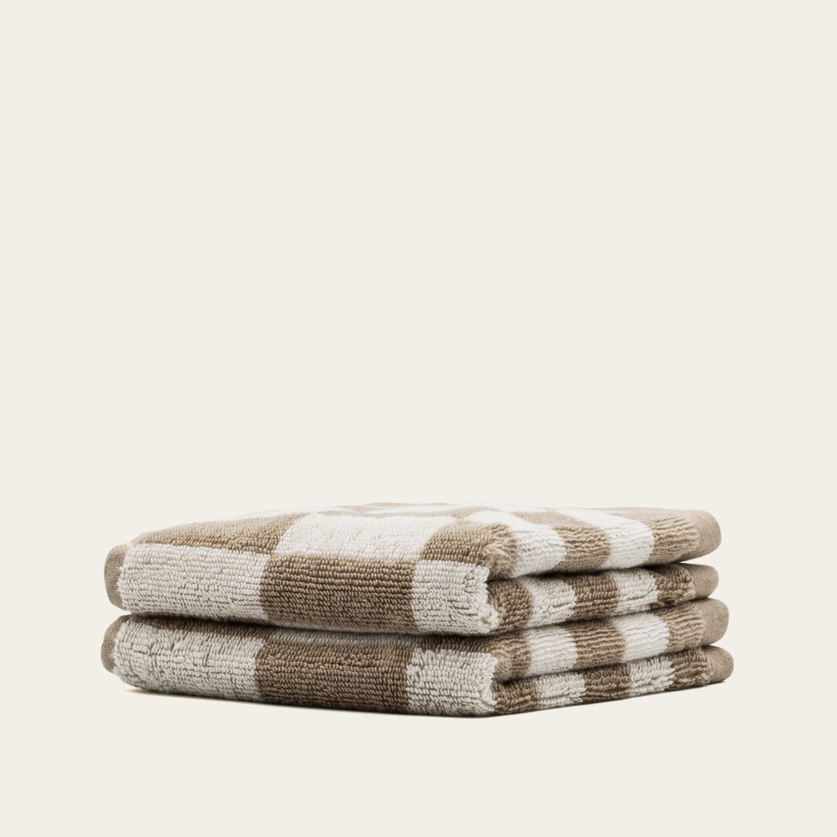 Checkerboard cotton towels in tan and ecru, folded set stack