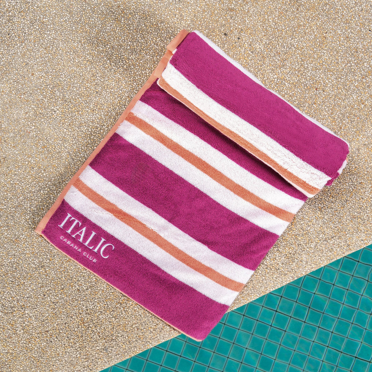 Magenta and white striped cotton beach towel with orange accent lines and ITALIC label