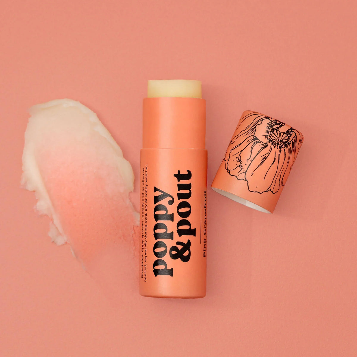 Pink grapefruit lip balm tube with yellow cap and peach-orange body