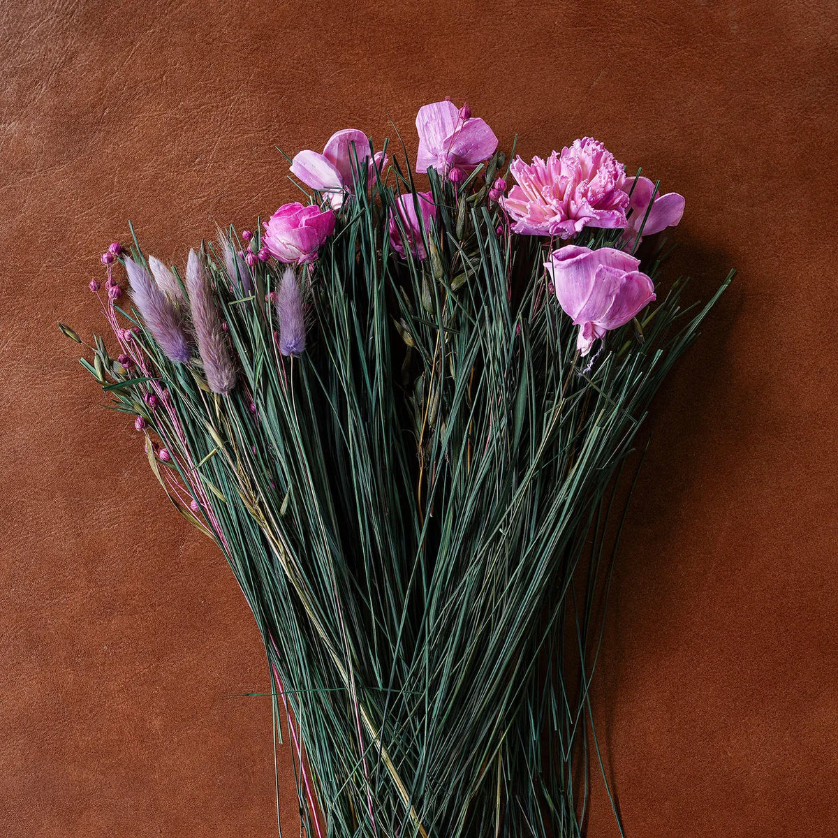 Dried floral and grass bouquet with purple blooms and green stems