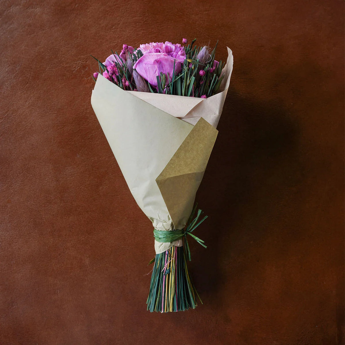 Wrapped dried floral bouquet with purple flowers and long multicolored grasses
