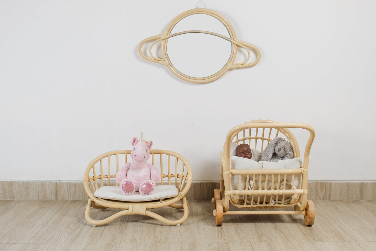 Front view of a rattan doll stroller with cushioned bedding and dolls inside