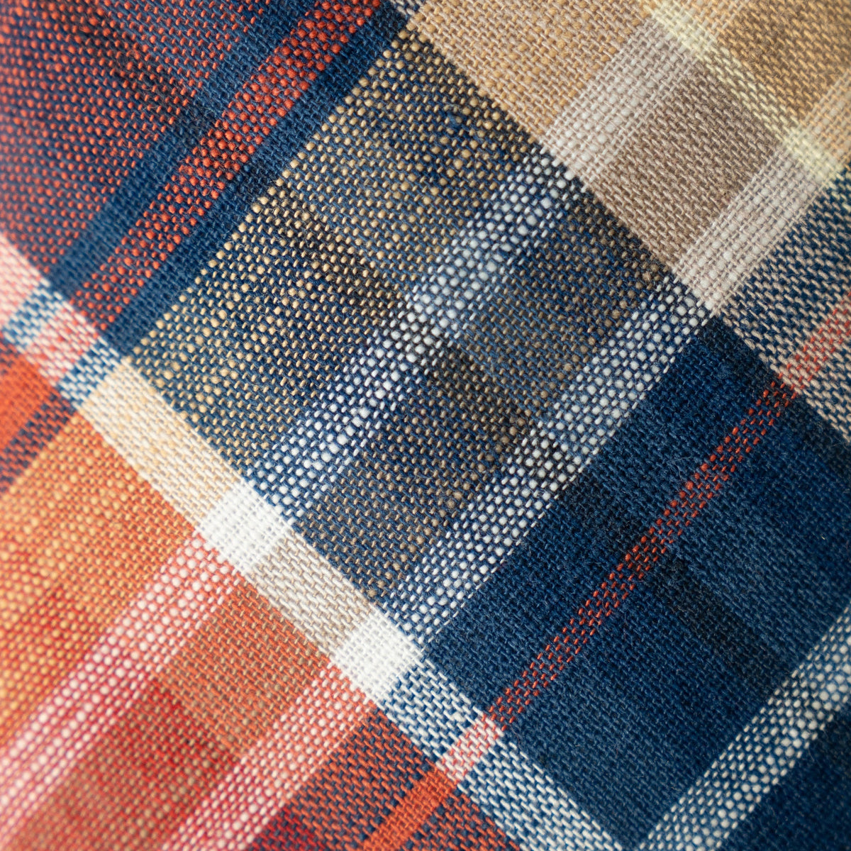 Plaid tie fabric close-up with orange, navy, and white checks and cross stripes