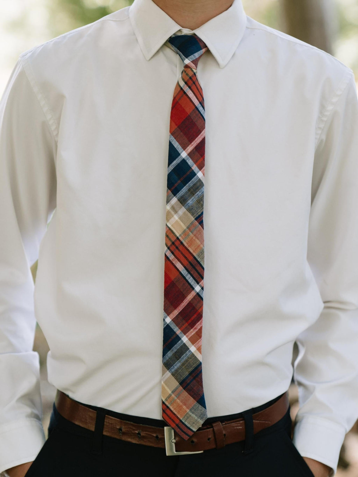 Youth plaid necktie worn with white dress shirt and brown belt