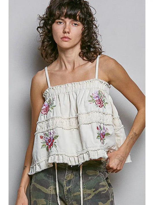 Ivory floral embroidered tank with thin straps, gathered seams, and a ruffled hem