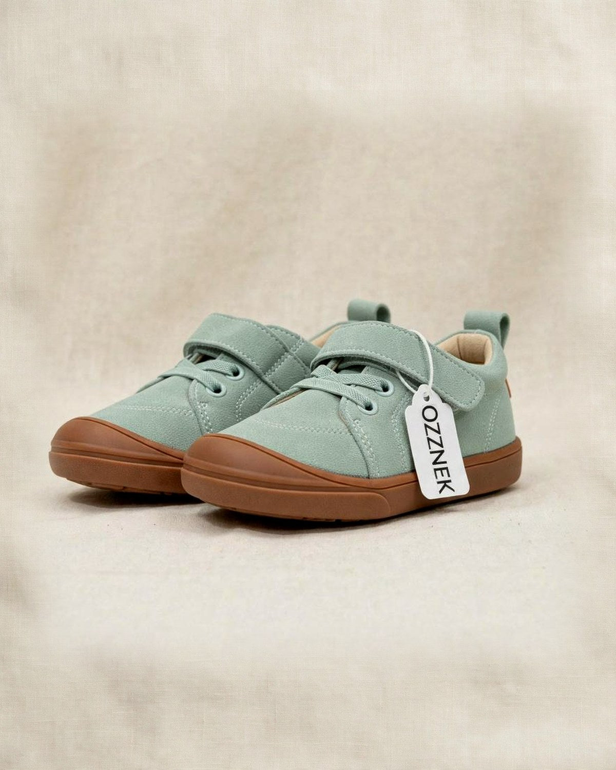 Kids’ light green suede barefoot sneakers with brown flexible sole and lace-up design