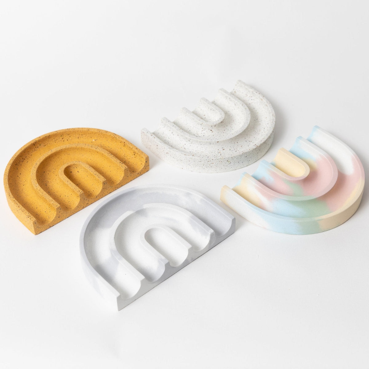 Set of sponge rests in white, pastel, and gold with open slots