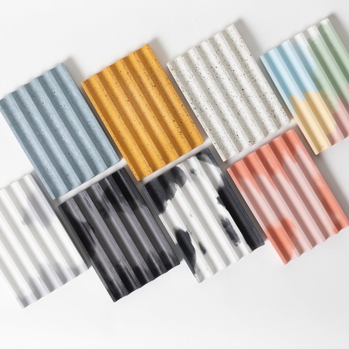 Assorted pastel striped soap trays in blue, gold, gray, and rose